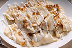 Dumplings with fried onions on white plate. Varenyky, vareniki, pierogi.