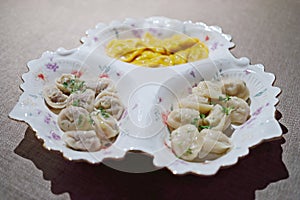 Dumplings on plate with three sections on table photo