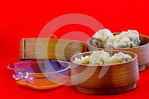 Dumplings are served on bamboo tray, ready to be enjoyed.