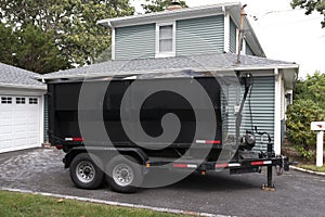 Dumpster on a trailer in a residential driveway