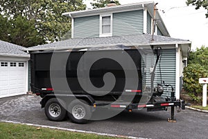 Dumpster on a trailer in a residential driveway photo