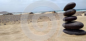 Dune di sabbia desertica in spiaggia con pila di sassi zen