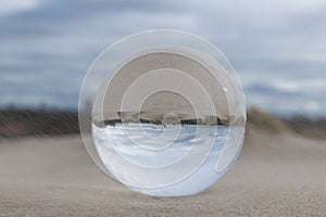 Dunes at the beach seen trough a lensball