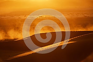 dunes, dust, and backlight at dusk in the desert