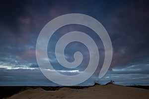 Dunes under a moody sky.