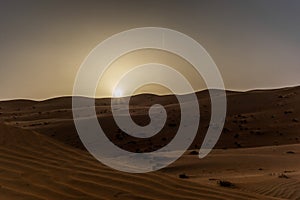 The dunes of the Wahiba Sands desert in Oman at sunset during a