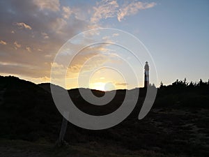 Dunescape in Amrum with lighthouse against sunset photo