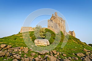 Dunguaire castle on green hill photo