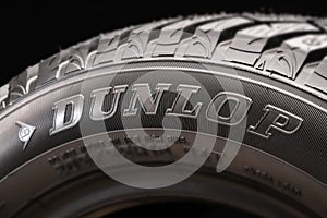 Dunlop logo is large on a black background, on the side of the new tire