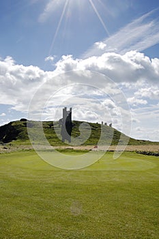 Dunstanburgh Castle and Golf green vertical