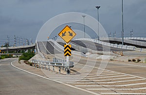 Duoble arrow and obstacle warning sign before crossing