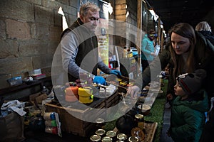 Cheese stall at food fair with mother and son looking at vendors samples