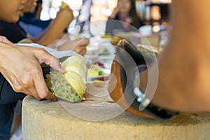 Durian Seller are showing how to open and explain informations and details to audiences about type of durain on the lunch table