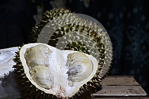 Durian Tropical Fruit cut in half wide open on dark background. portrait