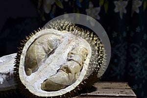 Durian Tropical Fruit cut in half wide open isolated on dark background. portrait