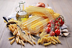 Durum wheat pasta and ingredients on wooden table