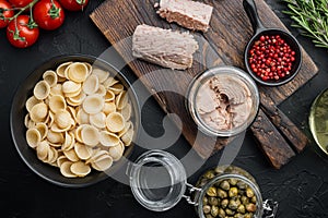 Durum wheat semolina tuna pasta ingredients, on black background, top view