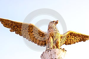 DUSHANBE, TAJIKISTAN - JULY 2, 2022: The statue of golden Brazen Eagle against the sky.