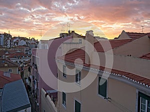 Dusk falls on the historic district of Mouraria in Lisbon, Portugal with a vivid sunset.