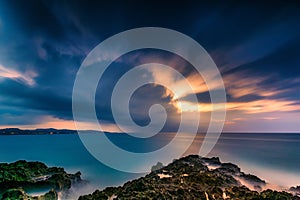 Dusk falls over a tropical rocky beach