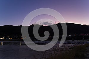 A dusk landscape of Togetsukyo bridge in Kyoto in autumn wide shot