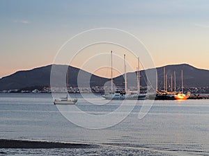 Dusk light reflected on boats at sunset, coast of Evvia Euboea, Greece, in Spring