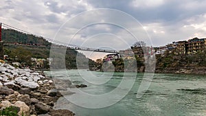 Dusk time lapse at Rishikesh, holy town and travel destination in India. Colorful sky and moving clouds over the Ganges River. Peo