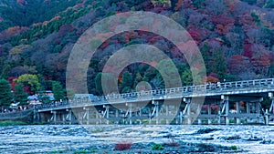 A dusk timelapse of Togetsukyo bridge in Kyoto in autumn telephoto shot