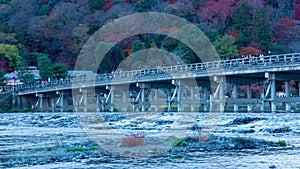 A dusk timelapse of Togetsukyo bridge in Kyoto in autumn telephoto shot panning