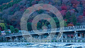 A dusk timelapse of Togetsukyo bridge in Kyoto in autumn telephoto shot zoom