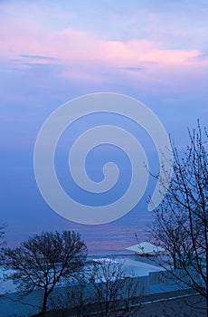 Dusk twilling on the Black sea in Odessa city beach. Early spring, blue evening, water horizon merging with sky in blue photo