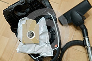 Dust bag full of garbage in the opened vacuum cleaner