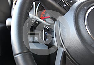 Dust On A Electronic Control Buttons On A Steering Wheel In Front Of Blurred Car Dashboard