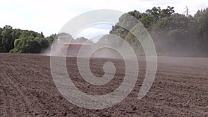 Dust rise from tractor fertilize prepare soil in field