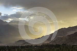 A dust storm in a mountain desert valley during sunset