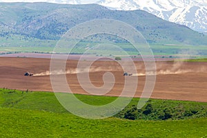 Dust from a tractor working in a field in spring