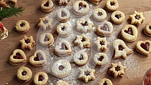 Dusting homemade Linzer Christmas cookies with sugar on a table