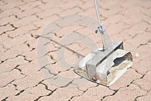 A dustpan on the background of street paving slabs. Cleaning dirt and dust from the streets of the city. With space to
