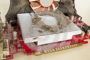 Dusty external graphics card out of a personal computer case for cleaning. A lot of dust on the cooling radiator of the video card