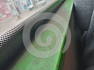 Dusty green window sill in the bus, public city transport
