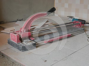 A dusty grungy tile cutter on freshly laid tiles - tiling tool / equipment