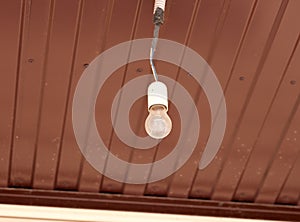 Dusty light bulb hanging from a ceiling