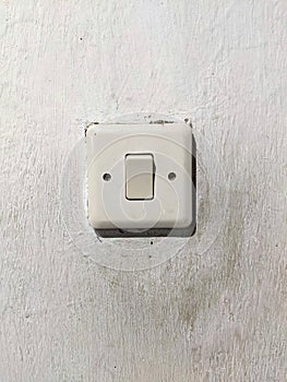 dusty old light switch on white wall