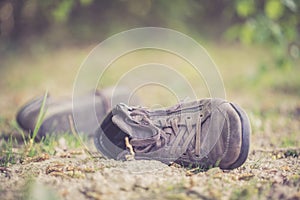 Missing and poverty concept: Abandoned shoe lying on the dusty ground