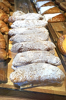 Dusty pastries aligned on a wooden surface