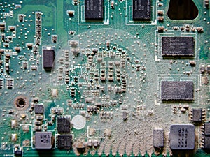 Dusty printed circuit board. Logic board covered with dust, close-up.