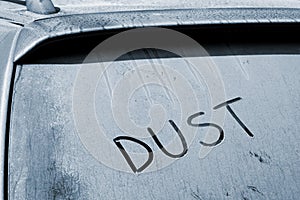 Dusty rear car windshield with word Dust written