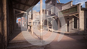 Dusty street in an old wild west town with boardwalk, gunsmith store and bank in late afternoon sunlight. Photo realistic 3D