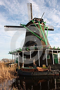 Dutch ancient windmill built from wood. typical structure of the Netherlands. old work tools on the river in the village of Zaanse