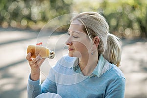 Dutch blonde woman eating fresh harring standing outdoors in Amsterdam